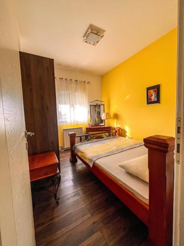 a bedroom with a bed and a yellow wall at Charming Countryside Villa with Garden & Terrace near Skadar Lake in Berislavci