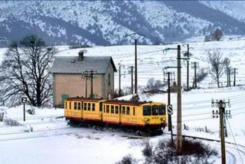 a yellow train on the tracks in the snow at Mobil home PREMIUM 8 personnes in Saillagouse