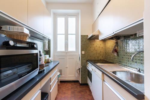 une petite cuisine avec un évier et un micro-ondes dans l'établissement Bonvin - CI - Parisian apt for 2p - View Tour Eiffel, à Paris