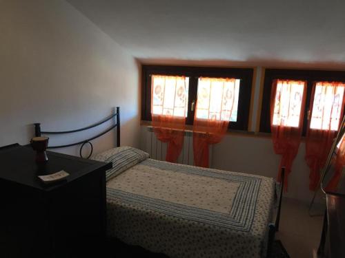 a bedroom with a bed and two windows at GIARDINI DI MARZO Casa vacanza in Poggio Bustone