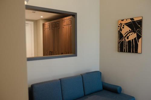 a blue couch in a room with a mirror at Emme Palace Hotel & Spa in Orvieto