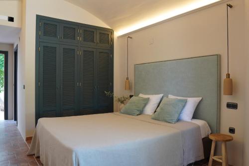 a bedroom with a large bed with green shutters at Hotel Finca Olivar in Benissa