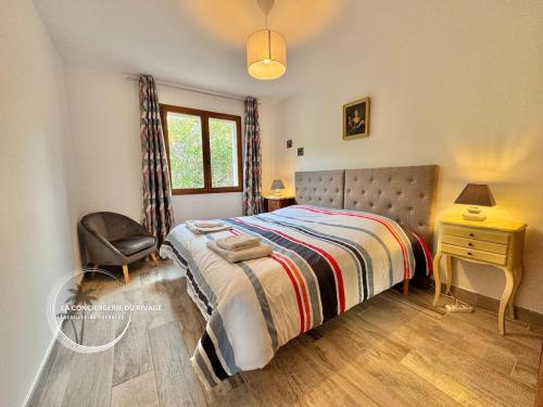 une chambre avec un lit, une chaise et une fenêtre dans l'établissement Villa Les Vignes du Paradis - Piscine - Jardin, à Carqueiranne