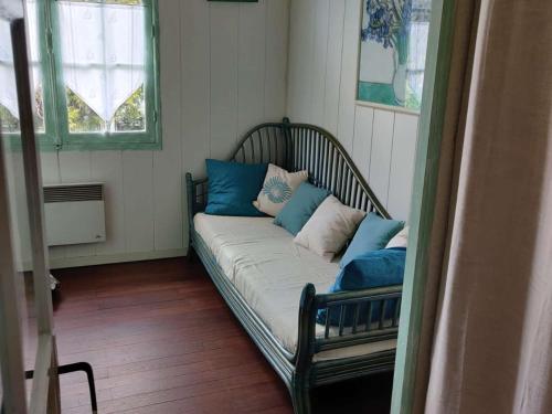 - un canapé avec des oreillers dans l'établissement Duplex 3 chambres, terrasse, à 600m de la plage - Noirmoutier - FR-1-224B-185, à Noirmoutier-en-l'lle