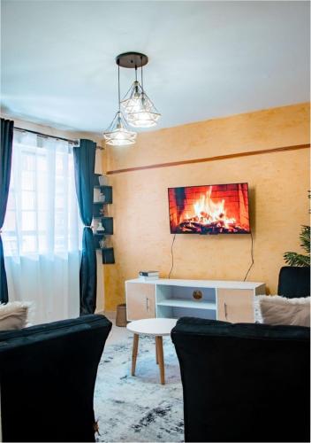 a living room with a fire on the wall at Afrikim Apartment Kahawa Sukari in Nairobi