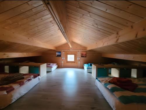 a room with three beds in a room with wooden ceilings at Ferienhaus Seeblick in Nöda