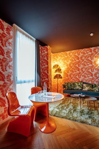 a living room with a table and chairs and a couch at Collini Rooms, WorldHotels Crafted in Milan