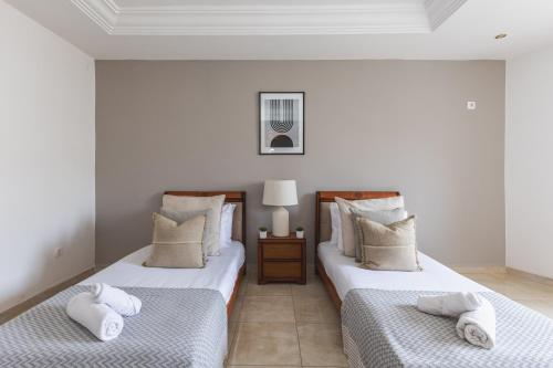 two beds sitting next to each other in a room at Appartement 4 pièces à Bir Mourad in Birmandreis