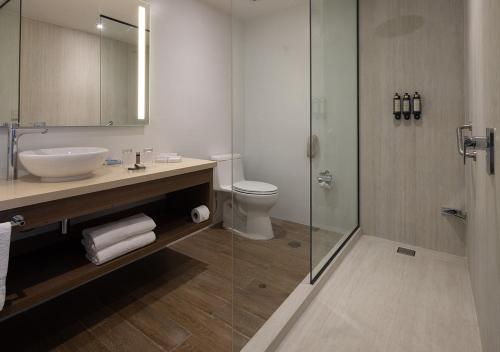 a bathroom with a sink and a toilet and a shower at Aranwa Paracas Resort & Spa in Paracas