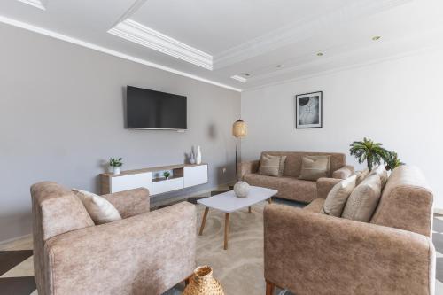 a living room with two couches and a tv at Appartement 4 pièces à Bir Mourad in Birmandreis