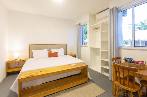 a bedroom with a bed and a desk and a window at Pousada Vila Flow in Cumbuco