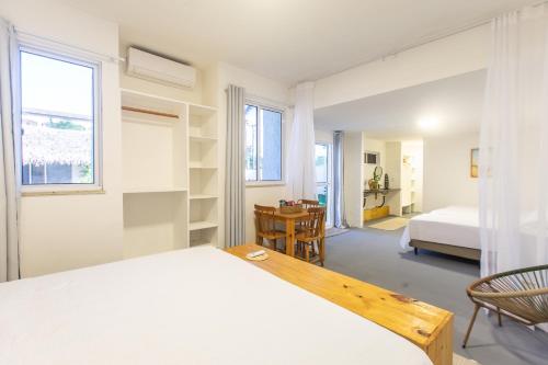 a bedroom with a bed and a desk in it at Pousada Vila Flow in Cumbuco