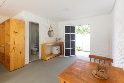 a living room with a wooden table and a toilet at Pousada Vila Flow in Cumbuco