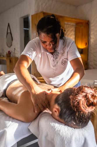 a woman giving a man a massage on a bed at Pousada Vila Flow in Cumbuco