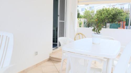 a white table and chairs in a room with a window at Cataldo Guest House in Capri