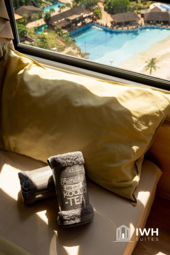 a towel sitting on a couch next to a window at Sunway Onsen Signature Themepark Suites with Hotspring by IWH Suites in Ipoh