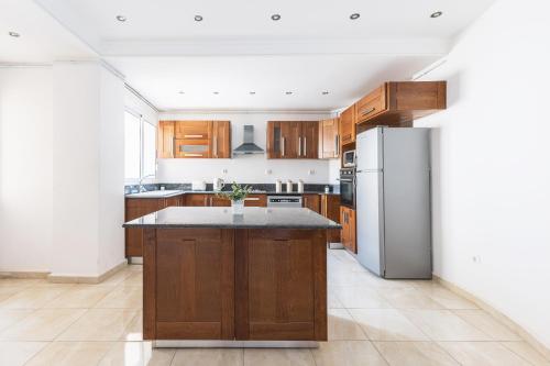 a kitchen with wooden cabinets and a stainless steel refrigerator at Appartement 4 pièces à Bir Mourad in Birmandreis