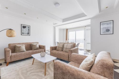 a living room with two couches and a table at Appartement 4 pièces à Bir Mourad in Birmandreis