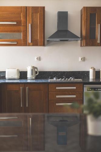a kitchen with wooden cabinets and a black counter top at Appartement 4 pièces à Bir Mourad in Birmandreis
