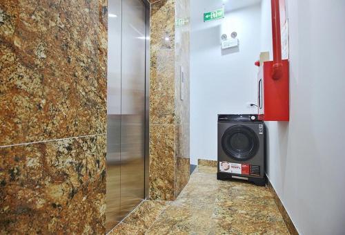 a bathroom with a shower with a washing machine at An'Home Apartment Westlake in Hanoi