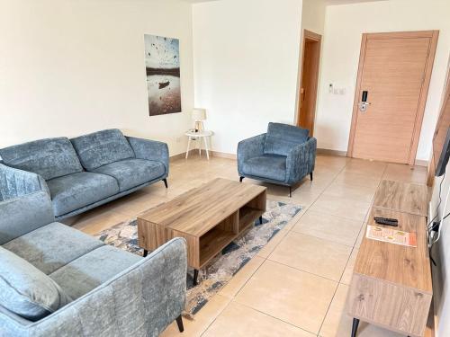 a living room with two couches and a coffee table at CasaNova Airport Suites in Accra