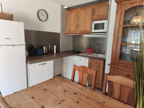 une cuisine avec des armoires en bois et une table et des chaises dans l'établissement Chalet de Montagne avec Parking à Cauterets - FR-1-812-123, à Cauterets