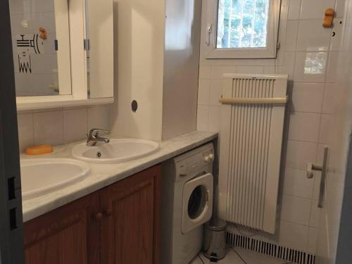 une salle de bain avec un lavabo et une machine à laver dans l'établissement Chalet de Montagne avec Parking à Cauterets - FR-1-812-123, à Cauterets