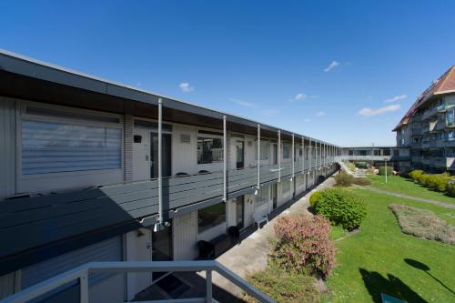 ein langes Gebäude mit Balkon und Hof in der Unterkunft die Perle in Zandvoort