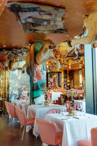 a restaurant with white tables and chairs and a mural at Collini Rooms, WorldHotels Crafted in Milan