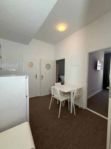 a room with a table and chairs and a refrigerator at Gremium Apartments in Bratislava