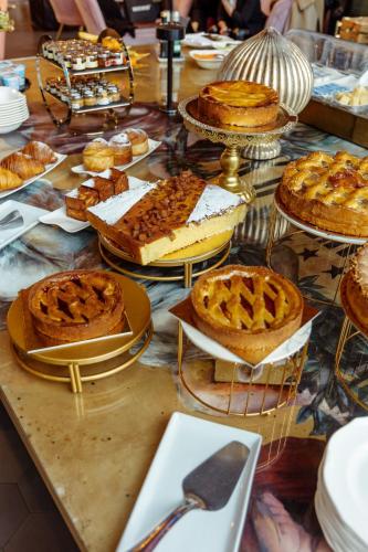 a table topped with pies and piesearcher at Collini Rooms, WorldHotels Crafted in Milan