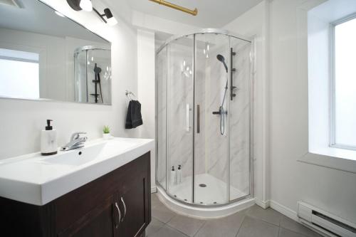 een witte badkamer met douche en wastafel bij Lion's Den // Spacious 1500 sqft (2 WC) - Downtown in Québec