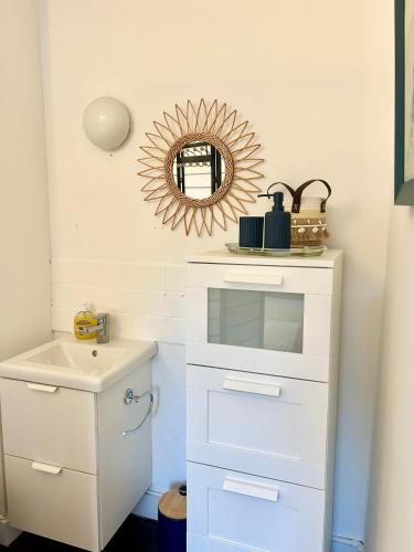 une salle de bain avec un lavabo et un miroir dans l'établissement La maison des écoliers, à Deauville