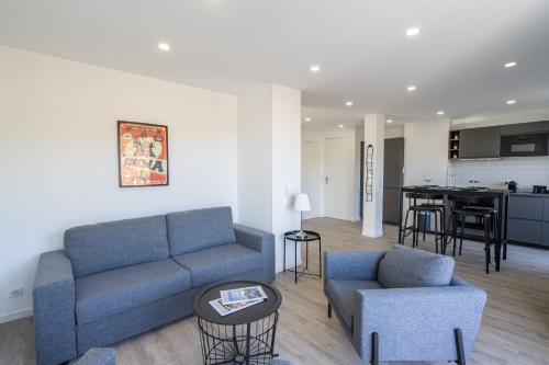 un salon avec un canapé et des chaises et une cuisine dans l'établissement La Ciotat T2 Climatisé Plage Lumière avec garage, à La Ciotat