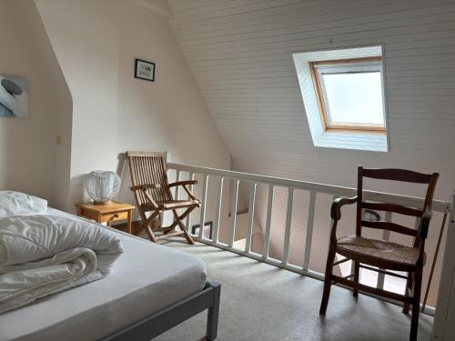 - une chambre avec un balcon doté de 2 chaises et d'un lit dans l'établissement Studio les Mouettes, à Perros-Guirec