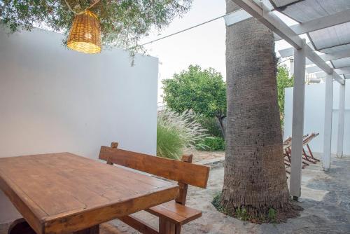 a wooden table and bench next to a tree at Gioma Garden Villas in Istron