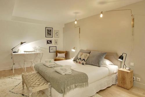 une chambre blanche avec un lit et une table dans l'établissement 2 appartements en 1 - Superbe logement près du Louvre l 12P, à Paris