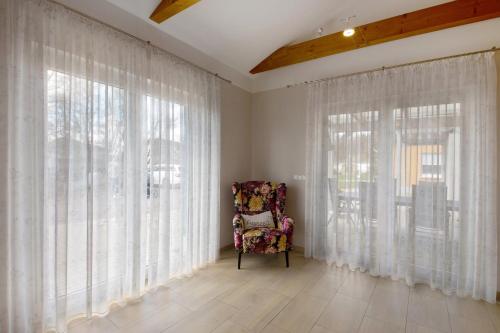 a chair sitting in a room with large windows at Lifestyle Ferienhaus in Pouch
