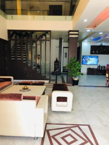 a living room with couches and a tv in a building at Hotel Kings Night in Greater Noida