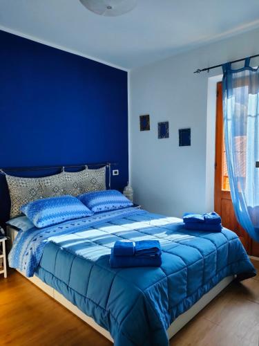 a blue bedroom with a large bed with blue sheets at Alley 8 in Scilla