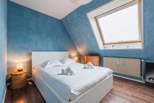 une chambre avec un lit blanc avec une grande fenêtre dans l'établissement Paul Reiss, à Strasbourg