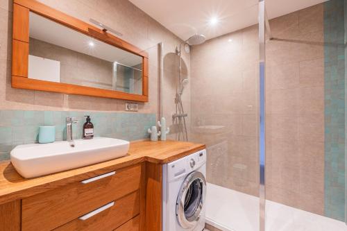 une salle de bain avec un lavabo et une machine à laver dans l'établissement Paul Reiss, à Strasbourg