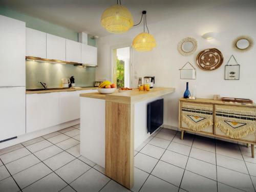une cuisine avec des armoires blanches et un comptoir dans l'établissement Villa Samasti - OVO Network, à Lacanau