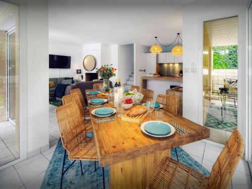 a dining room with a wooden table and chairs at Villa Samasti - OVO Network in Lacanau