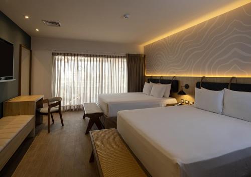 a hotel room with two beds and a couch at Aranwa Paracas Resort & Spa in Paracas