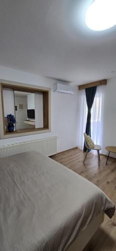 a bedroom with a bed and a window and a chair at Motel "KULA" in Cazin