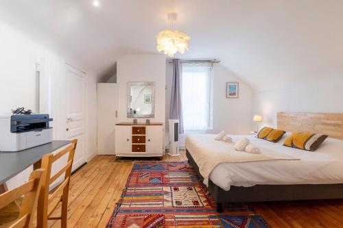 1 Schlafzimmer mit 2 Betten, einem Tisch und einer Mikrowelle in der Unterkunft Au cœur de la ville, traversant et tout confort in Vannes