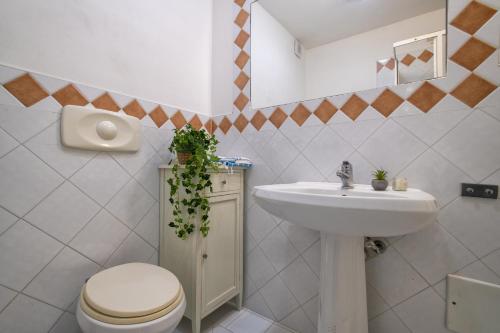 a bathroom with a toilet and a sink at Villa Azzurra in Stintino