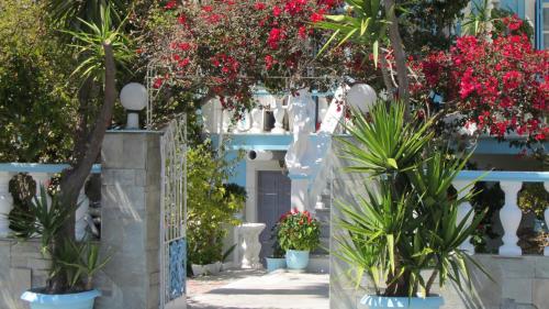 a white building with plants in front of it at Sandalis Hotel in Pythagoreio