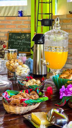 een tafel met manden met eten en sinaasappelsap bij Villa das Águas in Monte Alegre do Sul